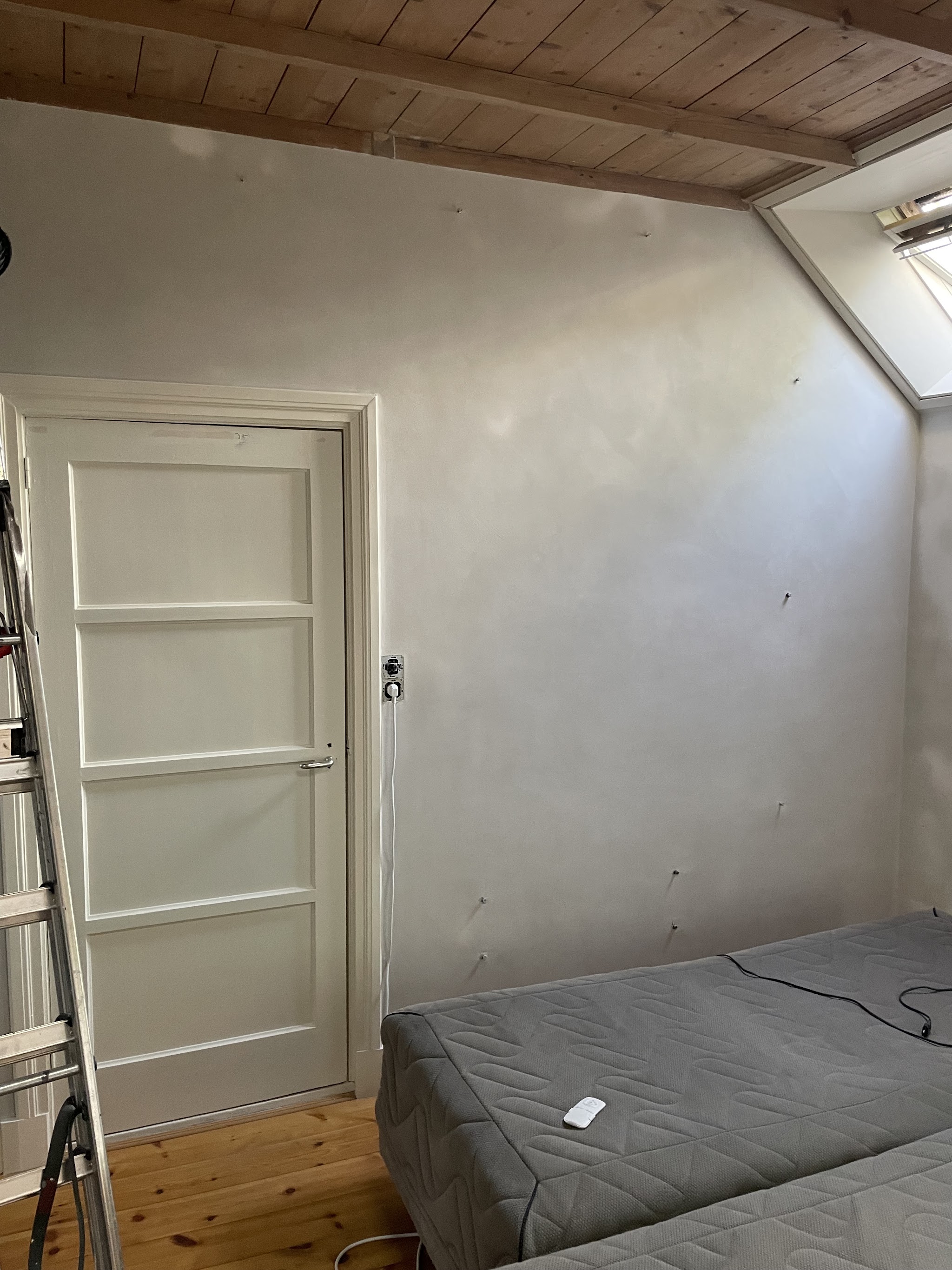 Slaapkamerwand rond een paneeldeur gestuct, nog aan het drogen