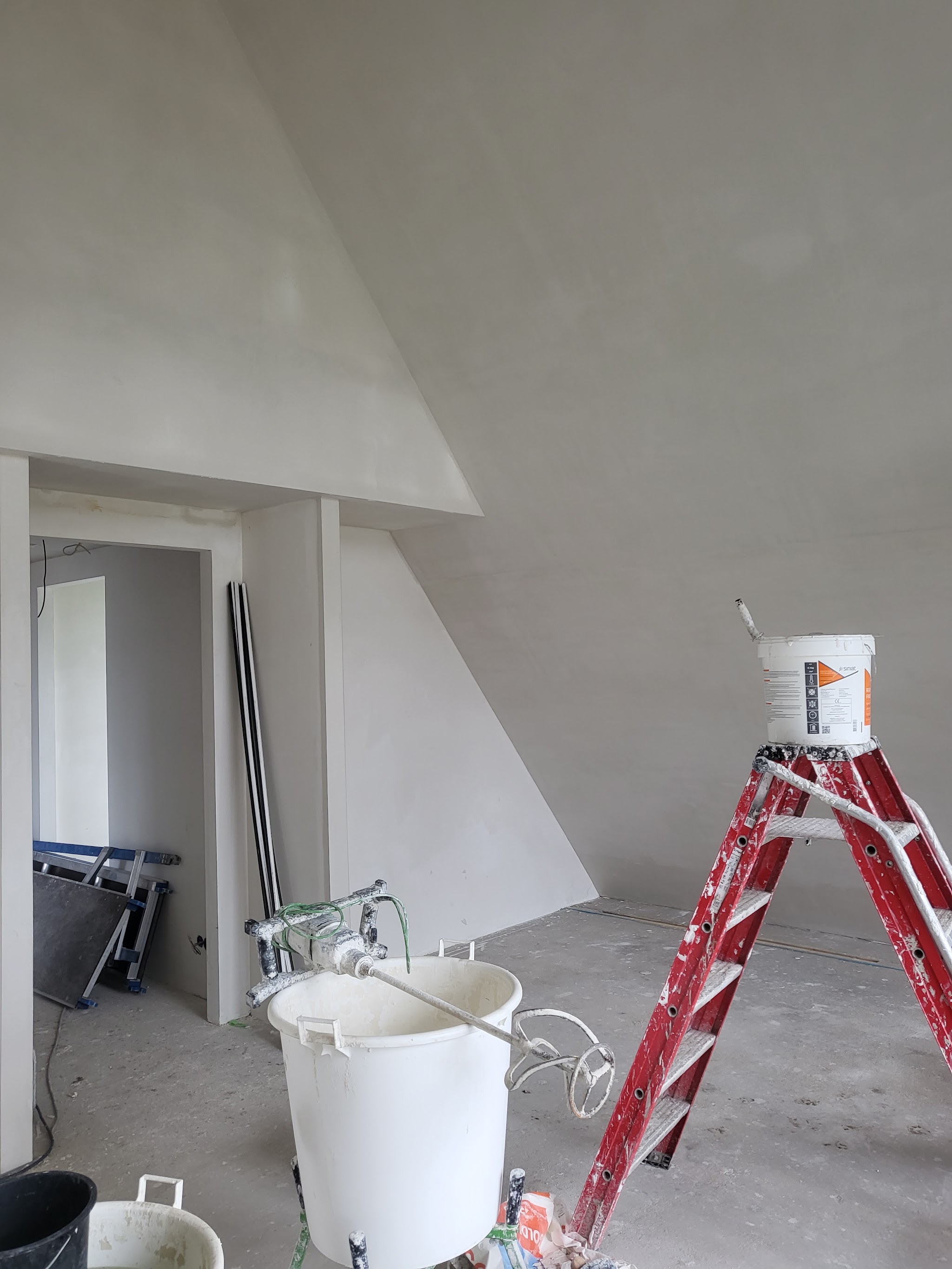 Zolderkamer met schuine wanden, strak gestuct