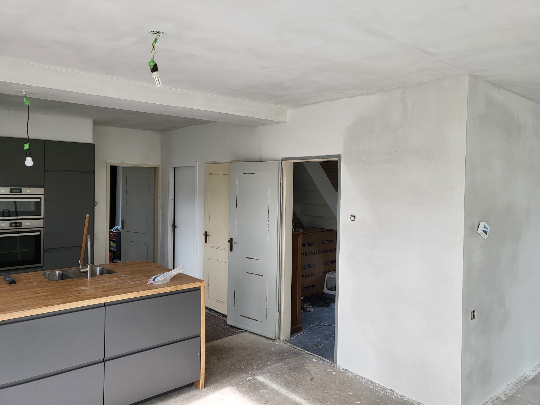 Open keuken en woonkamer met vers gestucte wanden en plafond